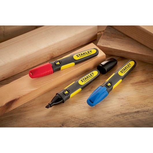 STANLEY SKU 0-47-315 permanent markers with red, blue, and black caps on wooden boards, angled view.