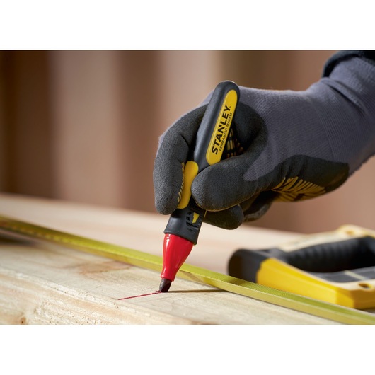 STANLEY 0-47-315 red marker pen used to mark a wooden plank, close-up photography.