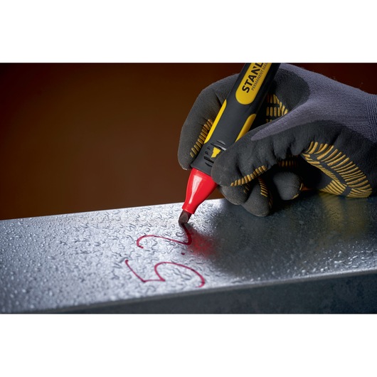 STANLEY 0-47-315 red marker used to write on wet metal surface, close-up photography.