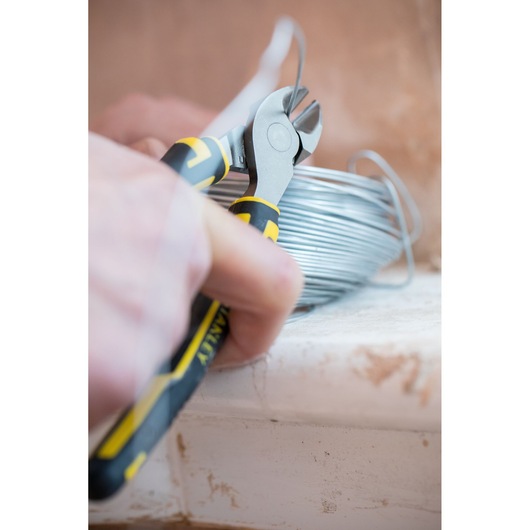 STANLEY 0-89-859 diagonal cutting pliers close-up cutting wire, black and yellow ergonomic handle.