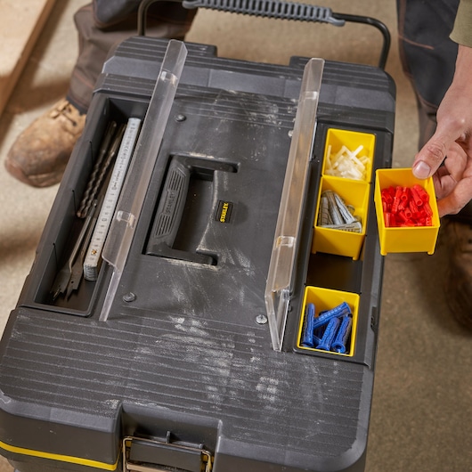 STANLEY 1-92-904 photography of black toolbox with transparent lid, yellow organizers, drill bits, wall plugs.