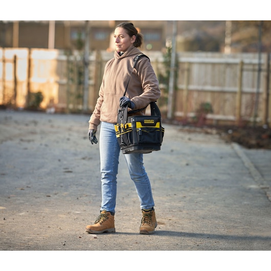 Photo of STANLEY 1-93-952 tool bag with shoulder strap carried by person in outdoor worksite.