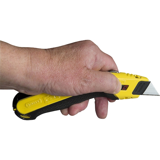 Photo of STANLEY 10-778 utility knife with yellow and black handle held in a hand, blade extended.