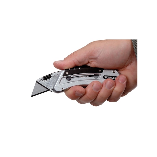 STANLEY 10-810 utility knife held in hand, silver and black handle, side view.