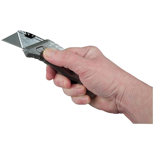 STANLEY 10-813 utility knife held in hand, close-up side angle, metallic handle and exposed blade.