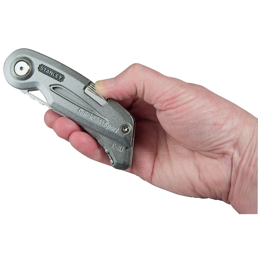 Photo of STANLEY 10-813 utility knife held in hand, silver metal body, side view, QuickSlide Sport model.