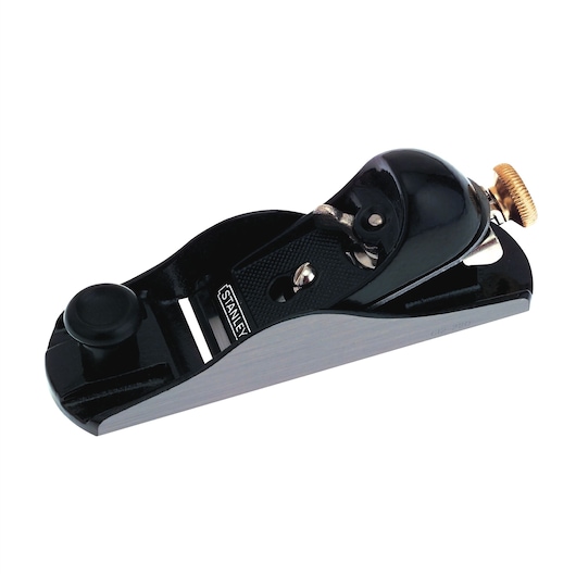STANLEY 12-220 block plane, woodworking hand tool, black metal body, side angle on white background.