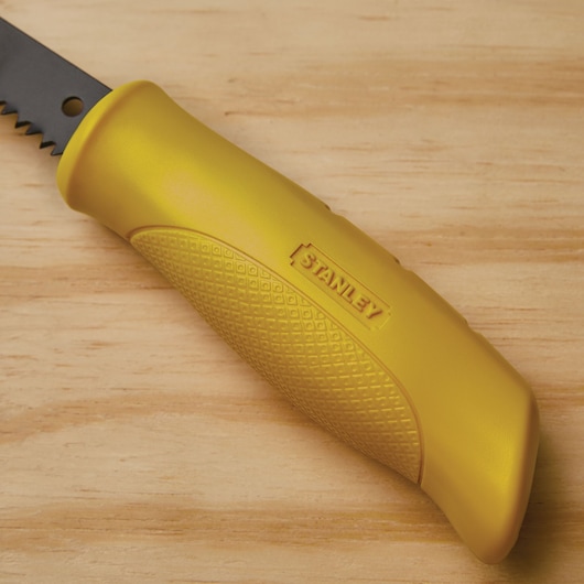 Stanley 15-556 saw handle, close-up view, yellow textured grip, on wood surface.