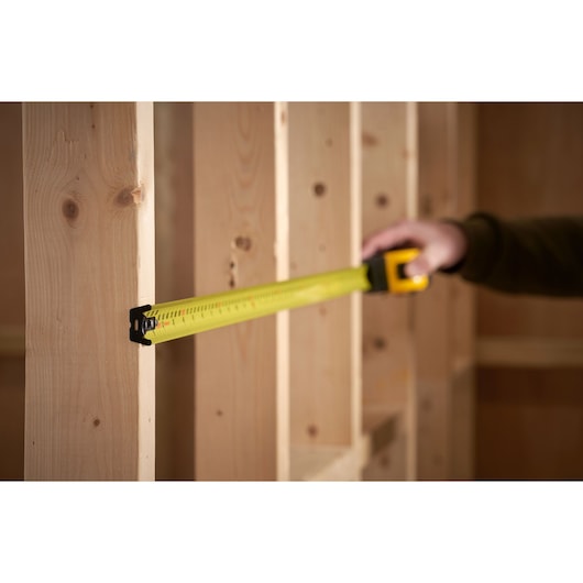 STANLEY 33-731 tape measure measuring wood studs, product in use, photography.