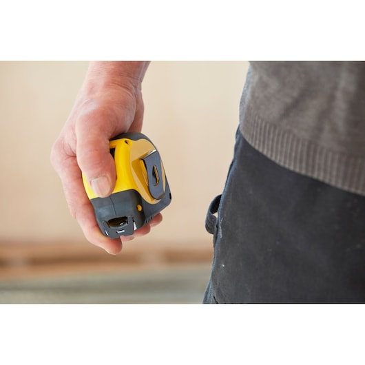 STANLEY 33-732 tape measure held in hand, yellow and black design, close-up photography.