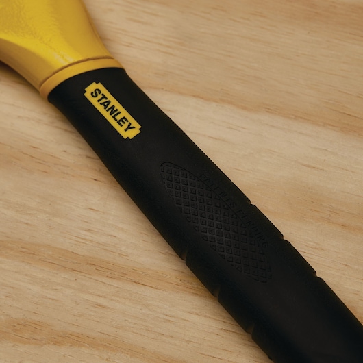 STANLEY 55-099 pry bar black and yellow handle close-up on wood surface.