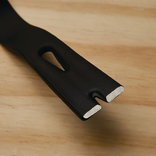 STANLEY 55-525 flat pry bar close-up, showing the notched, polished end and black finish on wood surface.