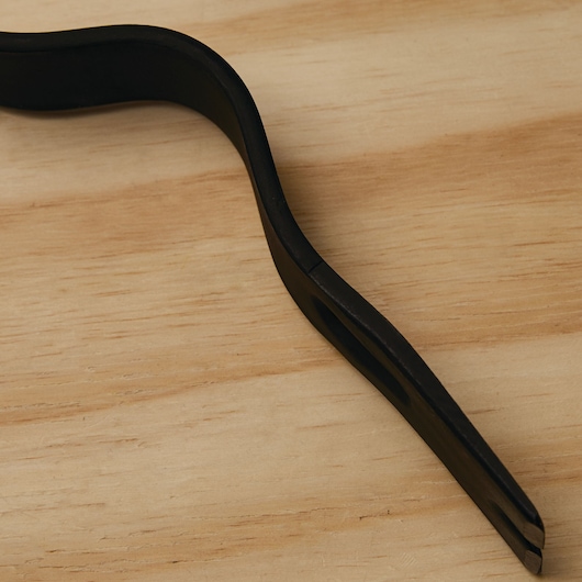 STANLEY 55-525 black pry bar with curved design, close-up on wood surface.