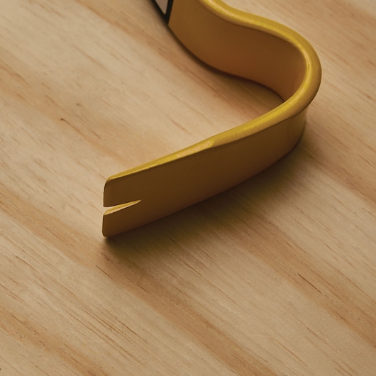 STANLEY 55-525 yellow pry bar tip with split end on a wood surface, close-up photography.