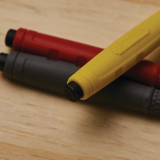 Photo of STANLEY 58-930 assorted color punch tools with yellow, red, and black handles on wood surface.