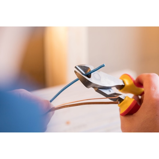 Photo of STANLEY 84-004-S wire cutter pliers cutting blue wire, close-up view.