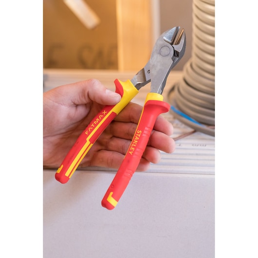 STANLEY 84-004-S insulated diagonal cutting pliers with red and yellow handles held in hand, close-up.