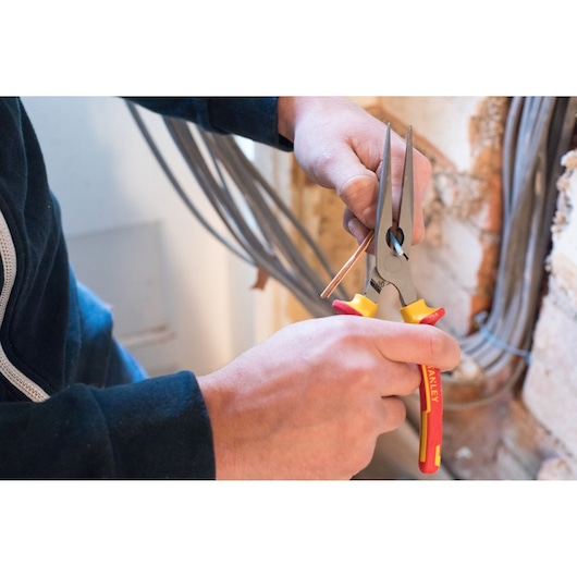 Photo of STANLEY 84-007-S long nose pliers being used to bend a copper wire near electrical cables.