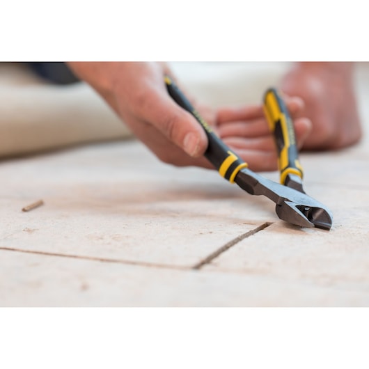 STANLEY 89-861 diagonal cutting pliers with yellow and black handle in use on tiled floor.
