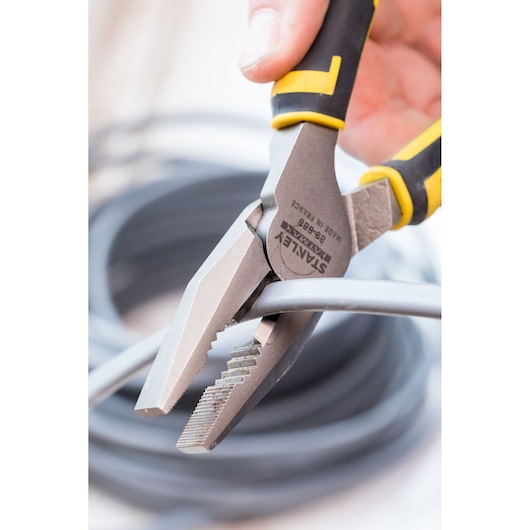 Stanley 89-868 photography of pliers with textured jaws gripping a cable, black and yellow handle.