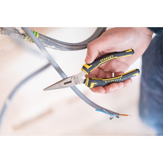 Stanley 89-869 FATMAX long nose pliers in hand cutting electrical wire, close-up photo.