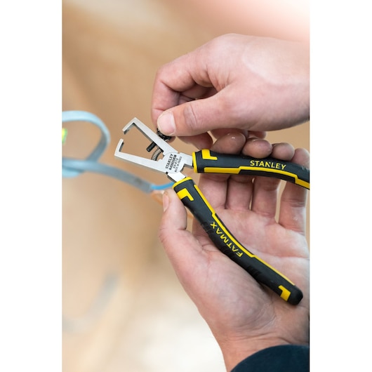 Photo of STANLEY 89-873 pliers with black and yellow handles being used to adjust a metal object.
