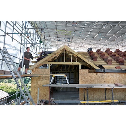 STANLEY FMHT36328 photography of saw horse on construction site with scaffolding and unfinished roof.