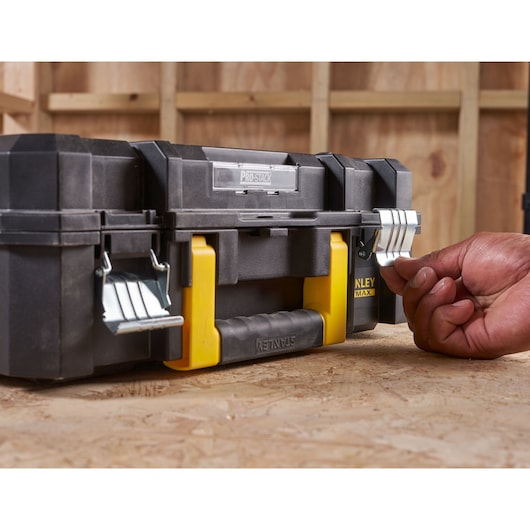 Photo of STANLEY FMST1-75502 black and yellow toolbox with metal latches on a workbench.