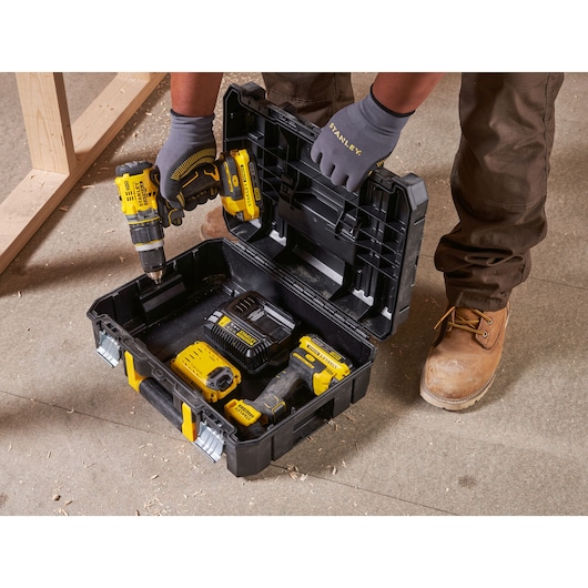 STANLEY FMST1-75502 black and yellow toolbox open on floor, holding power tools and accessories, viewed from above.