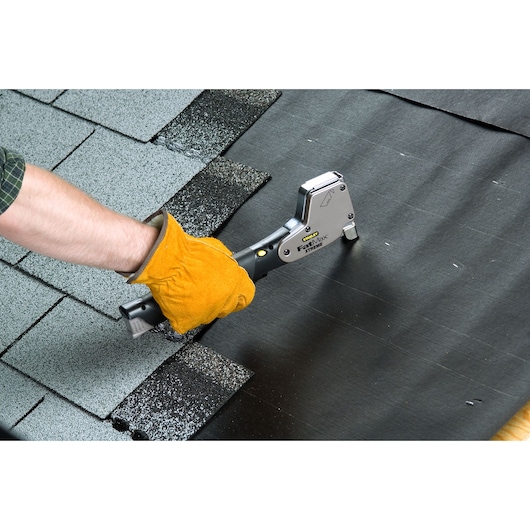 Photo of STANLEY PHT350T hammer tacker being used to secure roofing felt near shingles.