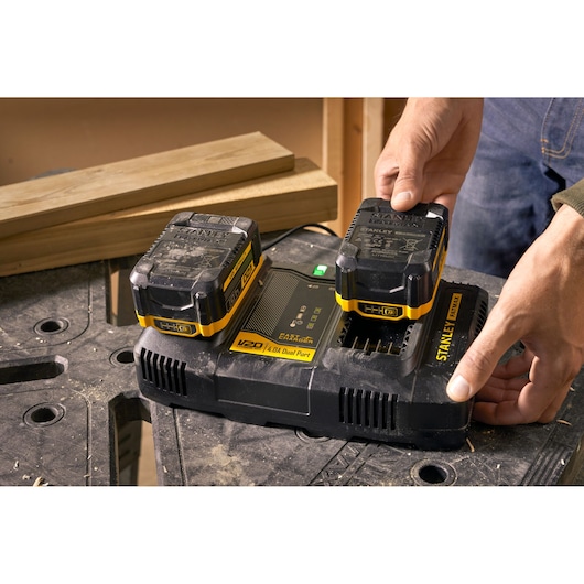 STANLEY SFMCB24 dual battery charger with two black and yellow batteries, close-up photography.