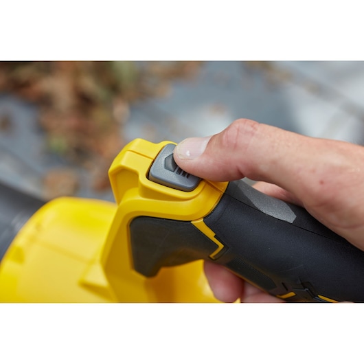 STANLEY SFMCBL7M1 leaf blower handle close-up with thumb pressing power button.