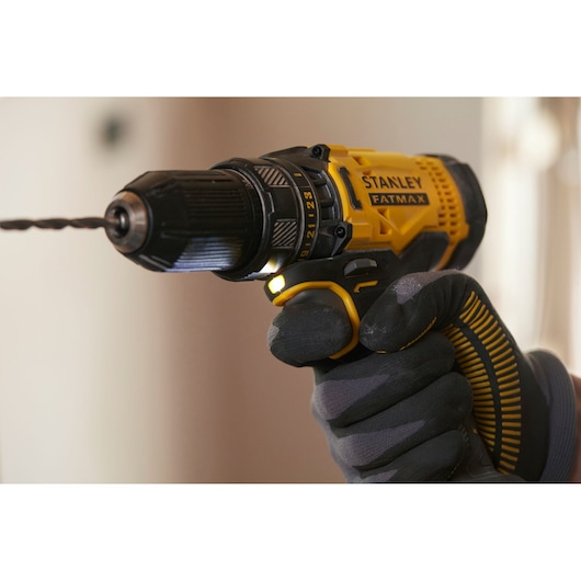STANLEY SFMCD700D2S cordless drill with drill bit in use, yellow and black, close-up side angle.