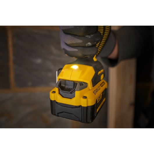 Photo of STANLEY SFMCF811B-XJ cordless impact driver in use, yellow and black, close-up view.