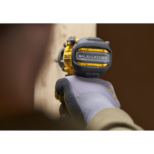 Stanley SFMCF830D2K brushless V20 cordless impact driver in use, close-up view of rear and grip.