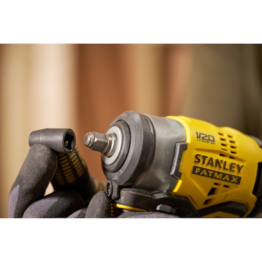 Photo of STANLEY SFMCF910B impact driver with socket attachment, close-up of tool front and yellow casing.