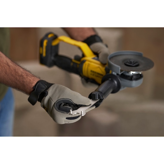 STANLEY SFMCG400M1S cordless angle grinder held by gloved hands, close-up side view.