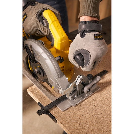STANLEY SFMCS550B circular saw close-up, yellow handle, cutting wood, operator wearing gloves.
