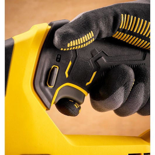 Photo of STANLEY SFMCS600B tool handle, close-up, black and yellow, held by gloved hand.