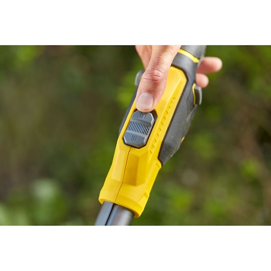 Photo of STANLEY SFMCSTB933M grass trimmer handle close-up showing yellow grip and dual-speed control switch.