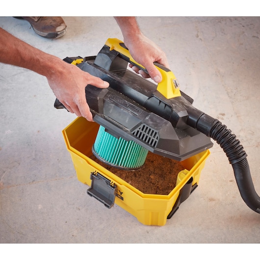 Photo of STANLEY SFMCV002B cordless wet/dry vacuum being opened, showing filter and dirt inside.