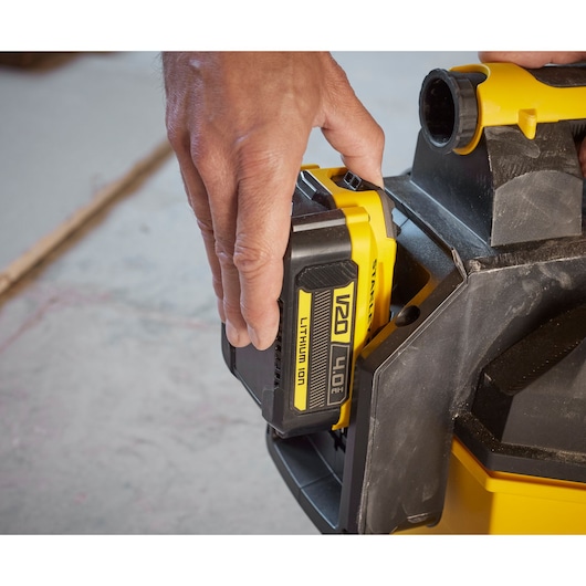 Photo of a hand installing a STANLEY V20 4.0Ah lithium-ion battery, SKU SFMCV002B, into a power tool side view.