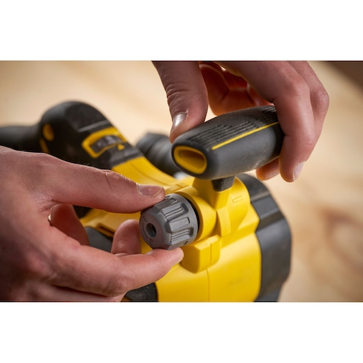 STANLEY SFMCW223B-XJ cordless planer detail, showing hand adjusting depth knob