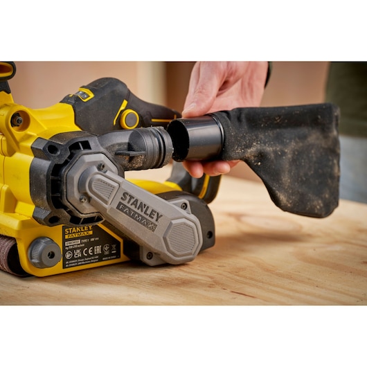 STANLEY SFMCW223B-XJ belt sander side view with dust bag being attached, yellow and black finish.