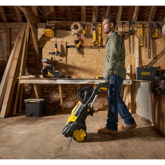 Photo of STANLEY SFMPW2400 pressure washer with yellow and black design in a workshop setting
