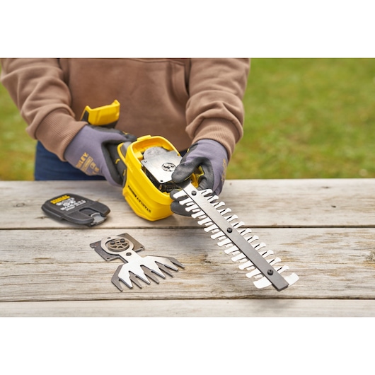 STANLEY STCSS20B hedge trimmer photography showing blade assembly and spare blades on wooden table.