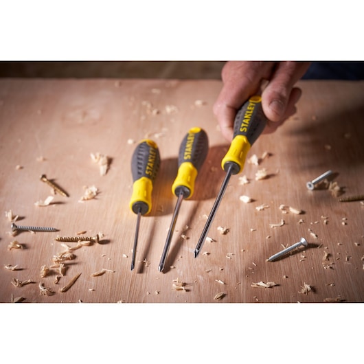 STANLEY STHT0-60276 screwdriver set with yellow and black handles on a wooden surface with screws.