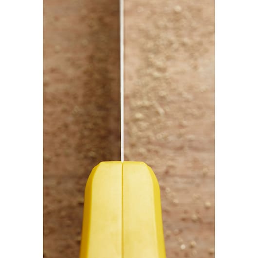 Photo of STANLEY STHT1-20353 saw handle with yellow grip, top view, blade aligned on wooden surface.