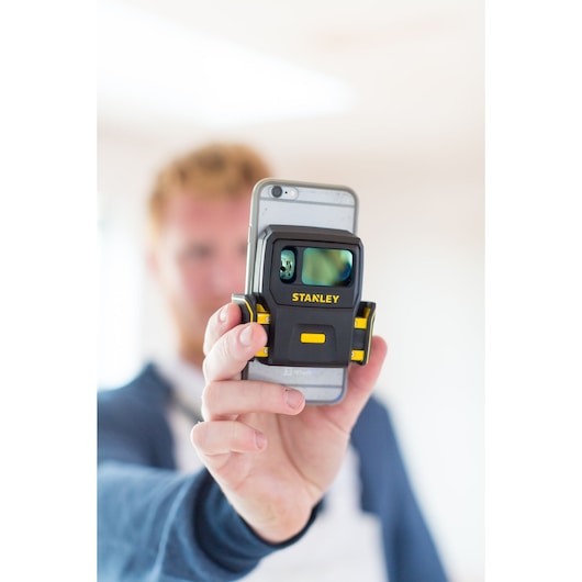 STANLEY STHT1-77366 laser measuring device held in hand, close-up.
