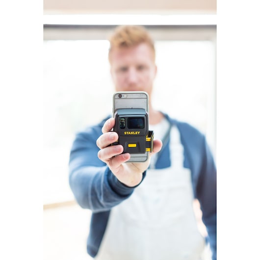 Photo of STANLEY STHT1-77366 laser distance measurer held in hand, focus on product front.
